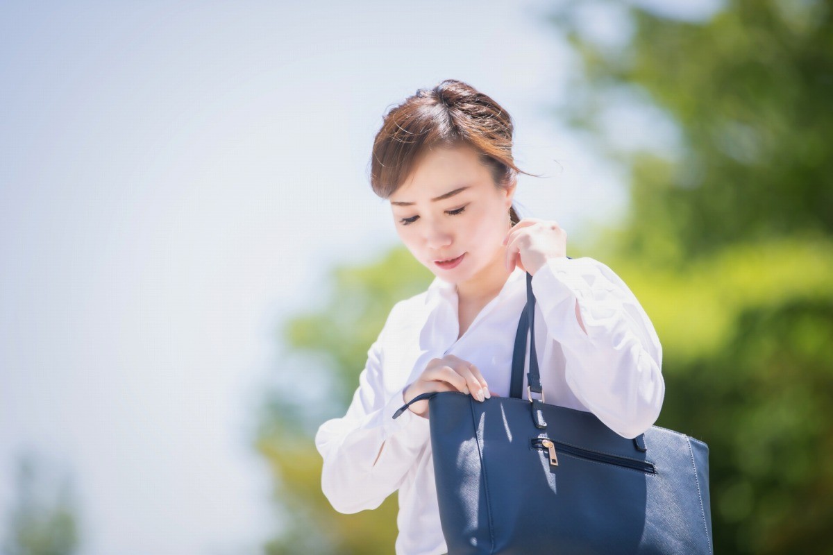 カバンの中を探る女性