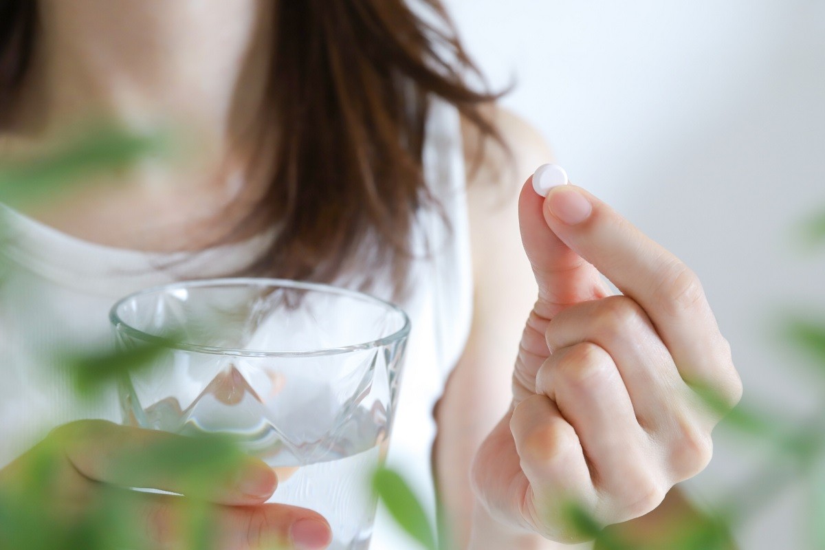 薬を飲む女性
