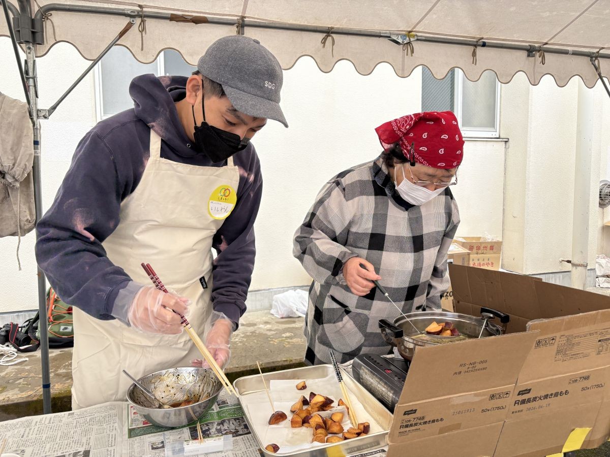 大学芋の調理補助をする編集部いしやん