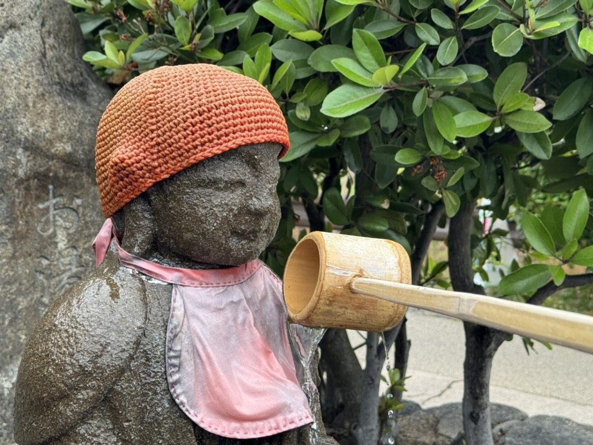 松江市千鳥町にある『お湯かけ地蔵尊』にお湯をかけているところ