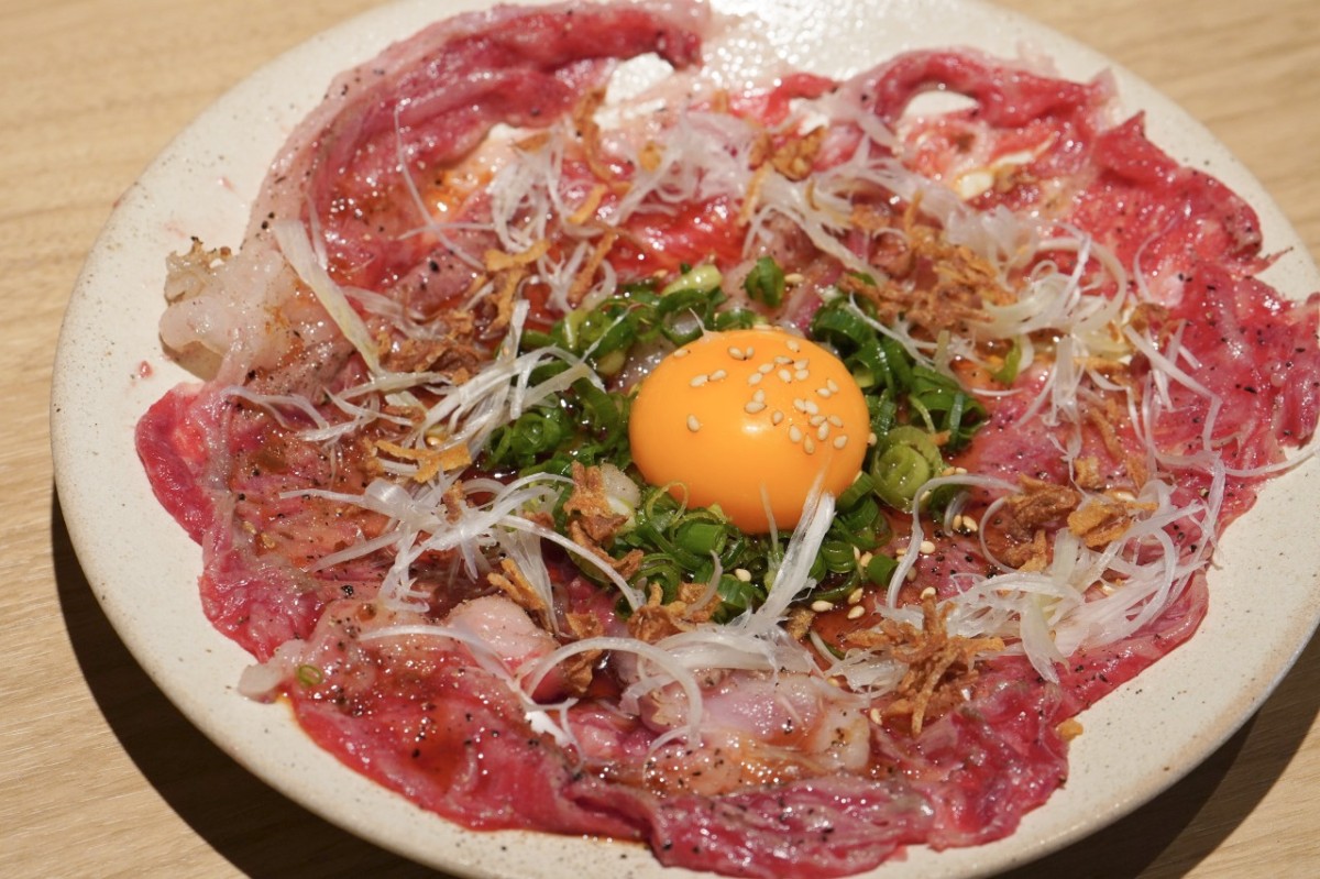 シャミネ鳥取「焼肉牛王」の万葉牛 飲めるロースユッケ。肉の中央にネギと卵黄を添えたひと皿