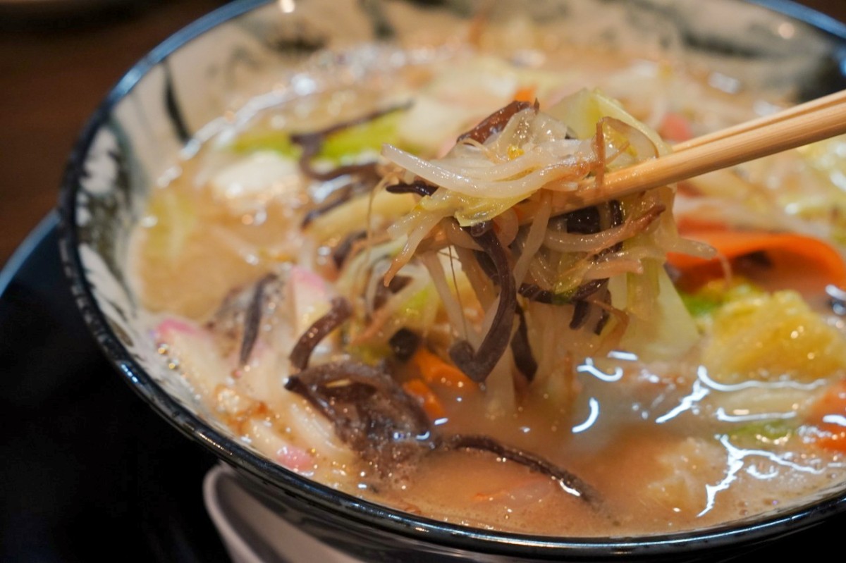 とんこつちゃんぽんの具材の下から麺を箸で持ち上げた様子