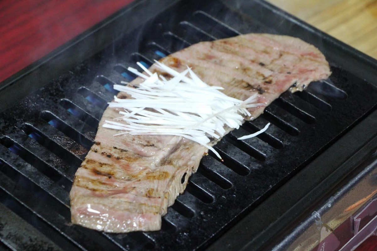 島根県松江市伊勢宮にある『叉鬼の焼肉酒場』で提供している「和牛たてわりタン」を焼く様子