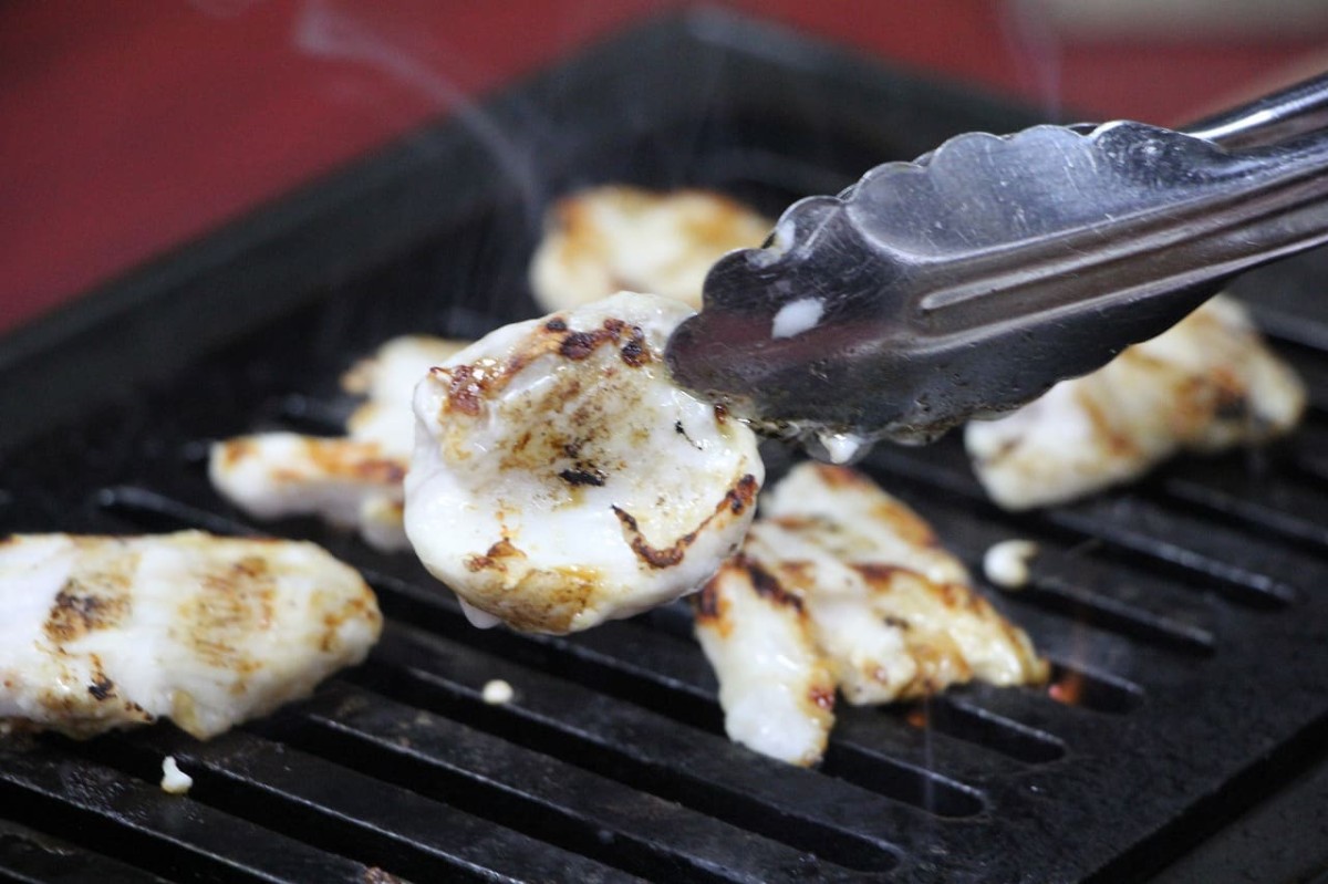島根県松江市伊勢宮にある『叉鬼の焼肉酒場』で提供しているジビエ肉「ワニ」を焼く様子