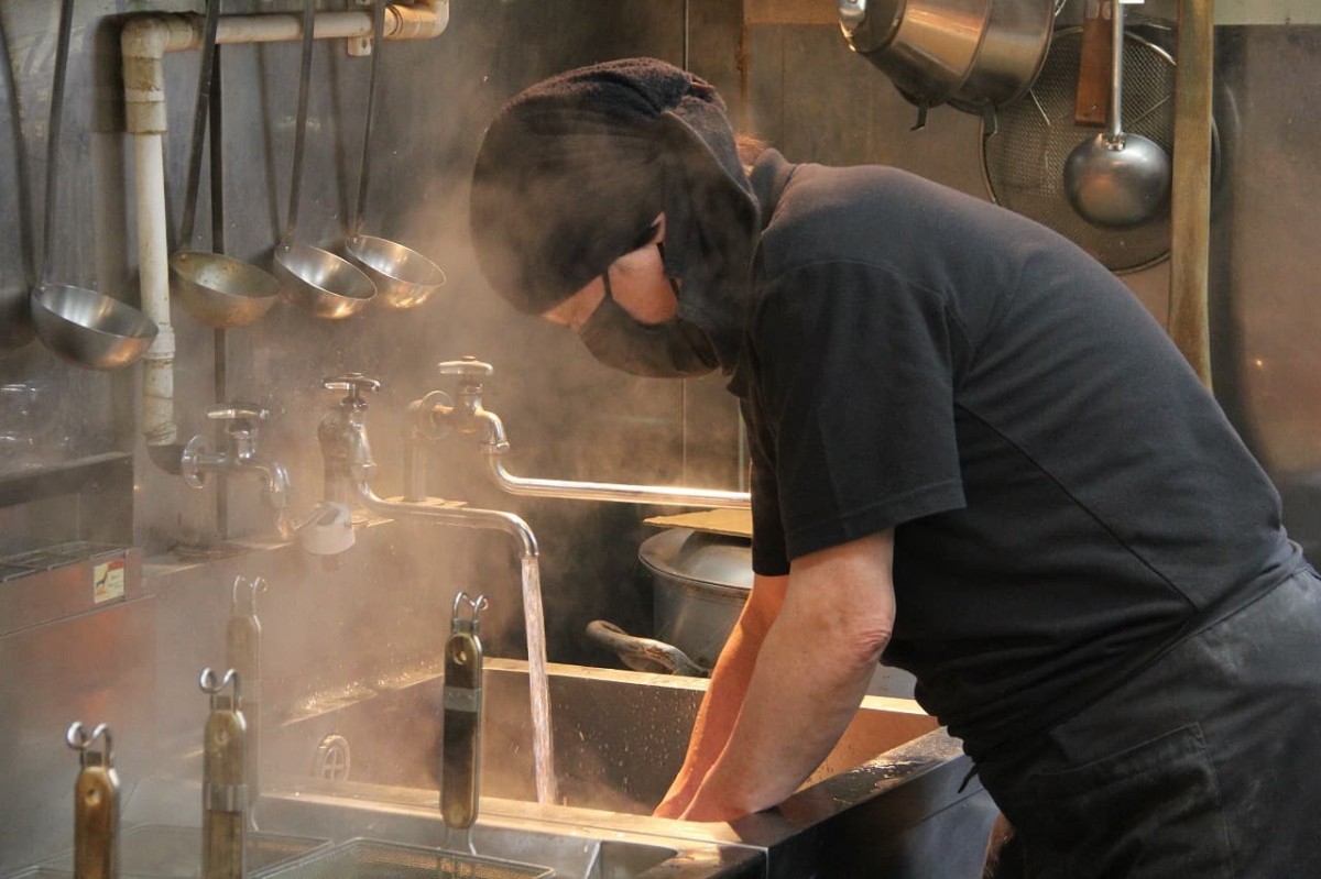 鳥取県米子市にあるラーメン店『麺処 三鈷峰』の店主が麺をしめる様子
