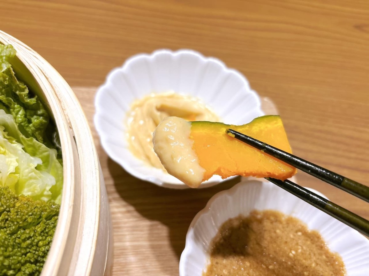 せいろで蒸したカボチャにタレを付ける。